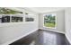 Living room featuring tile floors, paneled walls, two windows, and a view of the backyard and screen porch at 783 E Central Ave, Eagle Lake, FL 33839