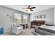 Bedroom with a rocking chair, wood crib, and large windows at 8120 Soldierwood St, Winter Garden, FL 34787