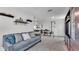 Large bonus room featuring a gray sofa with decorative pillows, shelves and an entertainment center at 8120 Soldierwood St, Winter Garden, FL 34787