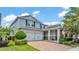 Charming two-story home with a manicured lawn, brick-paved driveway, and a two-car garage at 8120 Soldierwood St, Winter Garden, FL 34787