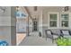 Covered front porch showing a seating area and view of a two-car garage and front door at 8120 Soldierwood St, Winter Garden, FL 34787