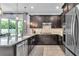 An elegant kitchen featuring dark wood cabinetry, granite countertops, stainless steel appliances, and stylish pendant lighting at 8120 Soldierwood St, Winter Garden, FL 34787