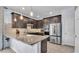 A modern kitchen featuring dark wood cabinetry, granite countertops, and stainless steel appliances at 8120 Soldierwood St, Winter Garden, FL 34787