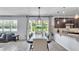 View of the kitchen and dining area leading to a patio, with dark cabinets, granite countertops, and modern lighting at 8120 Soldierwood St, Winter Garden, FL 34787