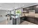 A stylish kitchen showcases dark wood cabinetry, granite countertops, stainless steel appliances, and views into the dining and living areas at 8120 Soldierwood St, Winter Garden, FL 34787