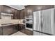A modern kitchen featuring stainless steel appliances, dark wood cabinetry, tile backsplash, and built in oven at 8120 Soldierwood St, Winter Garden, FL 34787