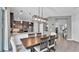 An open-concept kitchen and dining area with dark cabinetry, stainless steel appliances, granite countertops, and modern pendant lighting at 8120 Soldierwood St, Winter Garden, FL 34787