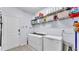 This lovely laundry room includes shelving and front loading washer and dryer at 8120 Soldierwood St, Winter Garden, FL 34787