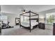Spacious primary bedroom boasts a four-poster bed, ceiling fan, and large window at 8120 Soldierwood St, Winter Garden, FL 34787