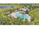 Aerial view of community pool, palm trees, lounge chairs and clubhouse by the lake at 8120 Soldierwood St, Winter Garden, FL 34787