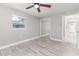 Spacious bedroom with ceiling fan, closet, wood-look floors and two windows at 906 E Lowell St, Lakeland, FL 33805