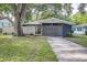 Charming single-story home with a modern exterior design, mature trees, and inviting curb appeal at 906 E Lowell St, Lakeland, FL 33805