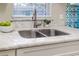 Close-up of kitchen sink with marble countertops and stainless steel faucet at 906 E Lowell St, Lakeland, FL 33805