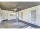 Enclosed lanai featuring a gray painted floor, neutral white walls, and an overhead ceiling fan at 906 E Lowell St, Lakeland, FL 33805