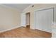 Bright bedroom features wood floors, white trim, a large closet, and convenient access to an adjacent room at 1018 E Highland Dr, Lakeland, FL 33813