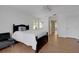 Light-filled bedroom features a black bedframe with a white comforter and an ensuite bathroom at 1018 E Highland Dr, Lakeland, FL 33813