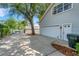 A side view of a house with a gray exterior and driveway surrounded by mature trees at 1018 E Highland Dr, Lakeland, FL 33813