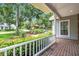 Charming front porch with decorative railing offers a welcoming spot to relax and enjoy the lush front yard at 1018 E Highland Dr, Lakeland, FL 33813