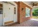 Inviting brick porch with a white front door and traditional details, perfect for greeting guests and enjoying the outdoors at 1018 E Highland Dr, Lakeland, FL 33813