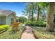 Landscaped walkway with mature trees, flowers, and shrubs creates an inviting path to the home at 1018 E Highland Dr, Lakeland, FL 33813