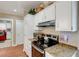 Kitchen features white cabinets, granite countertops, and stainless steel appliances plus adjacent red washer and dryer at 1018 E Highland Dr, Lakeland, FL 33813