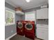 A laundry room with red washer and dryer, a sink, and storage cabinets for functional convenience at 1018 E Highland Dr, Lakeland, FL 33813