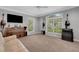 Spacious carpeted room featuring a piano, TV, and multiple windows with natural light at 1018 E Highland Dr, Lakeland, FL 33813