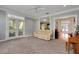 Inviting living room with carpet, sofa, piano and french doors leading to the backyard at 1018 E Highland Dr, Lakeland, FL 33813