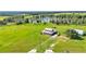 Aerial view of the house on a lush green parcel of land with a serene lake and a detached garage at 1044 Timbers Dr, Fort Meade, FL 33841
