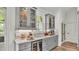 Stylish bar area featuring marble countertops, a wine fridge, glass display cabinets, and ample storage space at 1044 Timbers Dr, Fort Meade, FL 33841