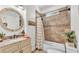 Bathroom featuring granite vanity, decorative mirror, and shower-tub combo with tile surround at 1044 Timbers Dr, Fort Meade, FL 33841