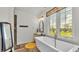 Elegant bathroom with a soaking tub, vanity, and view of the serene backyard at 1044 Timbers Dr, Fort Meade, FL 33841