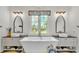 Luxurious main bathroom featuring dual vanities, a soaking tub, and a scenic view at 1044 Timbers Dr, Fort Meade, FL 33841
