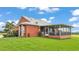 Charming home featuring a screened-in porch, well-maintained lawn, and beautiful landscaping at 1044 Timbers Dr, Fort Meade, FL 33841
