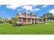 Charming one-story home featuring a metal roof, large front porch, and well-manicured lawn and landscape at 1044 Timbers Dr, Fort Meade, FL 33841