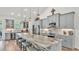 Modern kitchen featuring gray cabinetry, stainless steel appliances, an island with bar seating, and elegant pendant lighting at 1044 Timbers Dr, Fort Meade, FL 33841