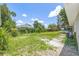 Wide angle view of a large grassy backyard surrounded by mature trees and partial view of the home at 1102 Berkley Ln, Winter Haven, FL 33880