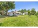Expansive backyard featuring lush lawn, mature trees, and charming single-story home and separate garage at 1102 Berkley Ln, Winter Haven, FL 33880