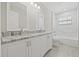 Elegant bathroom with double sinks, granite countertop, white cabinetry, and stylish tiled shower/tub combo at 1102 Berkley Ln, Winter Haven, FL 33880