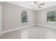 Bright bedroom with wood-look flooring and modern ceiling fan, bathed in natural light from two large windows at 1102 Berkley Ln, Winter Haven, FL 33880