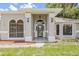 Close-up of the home's entry featuring arched windows, and a covered entrance at 1102 Berkley Ln, Winter Haven, FL 33880