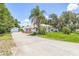 Wide shot of a house, driveway, and detached garage surrounded by lush trees at 1102 Berkley Ln, Winter Haven, FL 33880