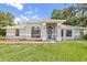 Charming home with a well-manicured lawn, arched windows, and a covered entryway at 1102 Berkley Ln, Winter Haven, FL 33880
