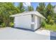 Detached single-car garage featuring a white door, exterior lights, and a well-maintained driveway at 1102 Berkley Ln, Winter Haven, FL 33880