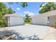 Spacious driveway leading to two separate garages, each with white doors and exterior lighting at 1102 Berkley Ln, Winter Haven, FL 33880
