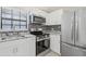 Modern kitchen featuring stainless steel appliances, granite countertops, and white cabinetry at 1102 Berkley Ln, Winter Haven, FL 33880