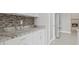 Detail of the kitchen granite countertops and tiled backsplash with white cabinetry and stainless steel refrigerator at 1102 Berkley Ln, Winter Haven, FL 33880