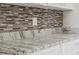 White kitchen cabinets with granite counters and a subway tile backsplash give this space a modern feel at 1102 Berkley Ln, Winter Haven, FL 33880