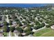 Expansive aerial shot of a residential neighborhood with lush greenery and a lake in the background at 1125 Blackjack Ridge St, Minneola, FL 34715