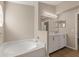 Bright bathroom features a soaking tub and white vanity with granite counters at 1125 Blackjack Ridge St, Minneola, FL 34715